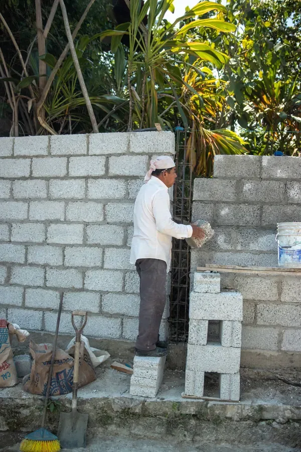 Mason laying a concrete block wall